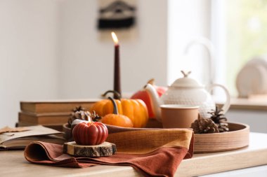 Mutfaktaki masada balkabağı şeklinde yanan mum, yakın plan.