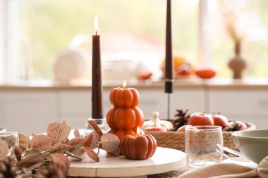 Mutfak penceresinin yanında yanan mumlarla sonbahar masası ayarı, yakın plan.