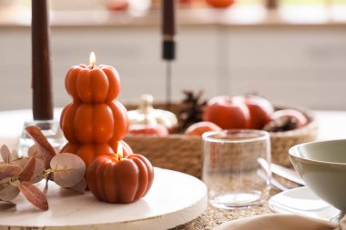 Mutfak penceresinin yanında yanan mumlarla sonbahar masası ayarı, yakın plan.