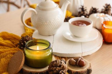 Mutfaktaki masada sonbahar dekorasyonu ve yanan mum, yakın plan.