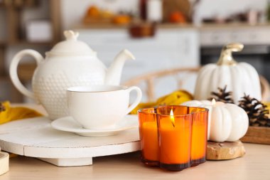 Çaydanlık, çay ve yanan mum mutfakta, yakın plan.