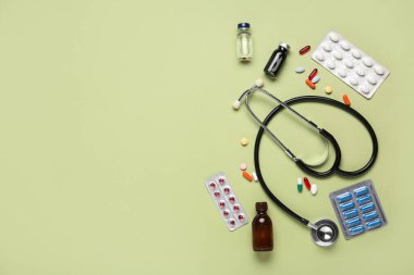 Yeşil arka planda haplar, ampuller ve steteskoplu kompozisyon. Nobel ödül günü kutlaması