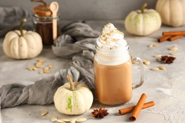 Mason kavanozu, krem şantili ve tarçınlı balkabaklı latte.