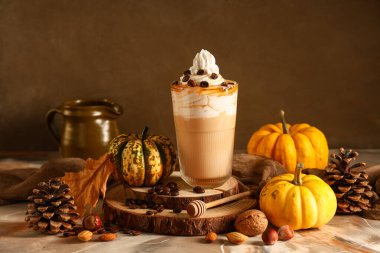 Krem şantili ve kahve çekirdekli bir bardak sıcak kabaklı latte.