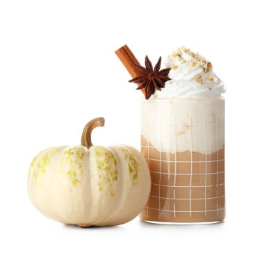 Krem şantili, tarçınlı ve beyaz arka planda yıldız anasonlu bir bardak sıcak kabaklı latte.