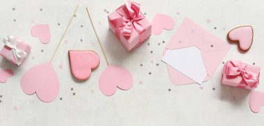 Kalp şeklinde tatlı kurabiyeler ve beyaz arka planda zarf olan hediye kutuları. Sevgililer Günü kutlaması