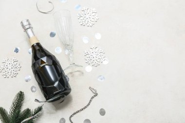 Noel süslemeli bir şişe şampanya ve grunge beyaz arka planda köknar dalı.