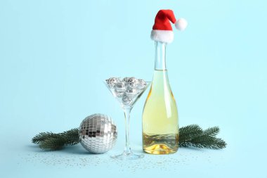 Mavi arka planda şampanya, cam ve disko toplarıyla Noel kompozisyonu