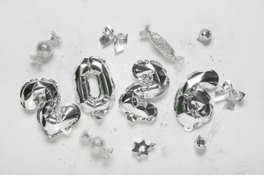 Beyaz arka planda balonlardan ve Noel toplarından yapılmış 2026 şekli