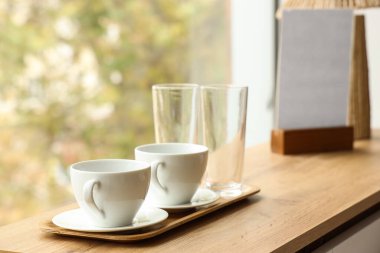 Süslü otel odasındaki ahşap masada çay tepsisi, yakın plan.