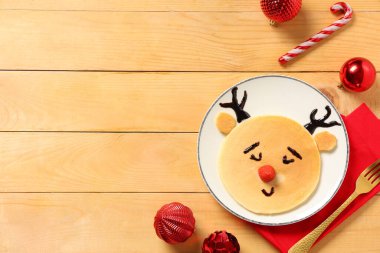 Tahta arka planda Noel Baba geyiği şeklinde gözleme tabağı.