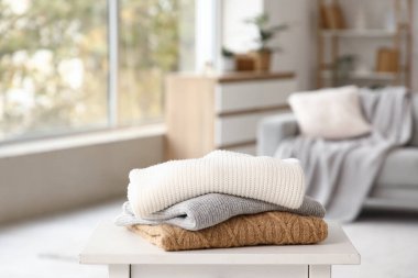 Katlanmış kışlık giysiler masanın üstünde, yakın plan.