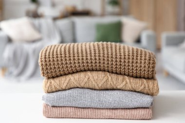 Katlanmış kışlık giysiler masanın üstünde, yakın plan.