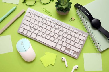 Fare, sulu ve yeşil arkaplanda ofis kırtasiyesine sahip bilgisayar klavyesi