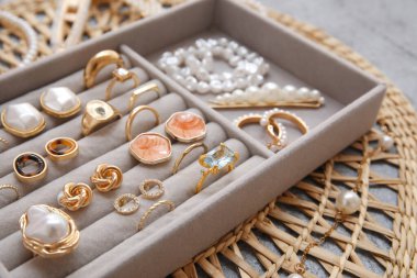 Gri grunge arka planda farklı altın takılara sahip eski ve düzenleyici, yakın plan