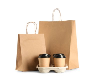 Beyaz arka planda kahve fincanları olan kağıt poşetler.