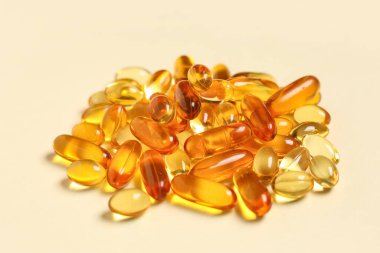 Bej arka planda E vitamini kapsülleri yığını