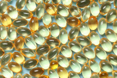 Mavi zemin üzerinde E vitamini kapsüllerinin dokusu