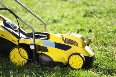 Yeşil çimlerin üzerinde modern çim biçme makinesi.