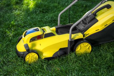 Yeşil çimlerin üzerinde modern çim biçme makinesi.