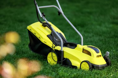 Yeşil çimlerin üzerinde modern çim biçme makinesi.