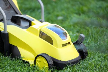 Modern çim biçme makinesi açık havada, yakın plan.