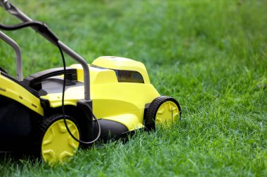 Yeşil çimlerin üzerinde modern çim biçme makinesi.