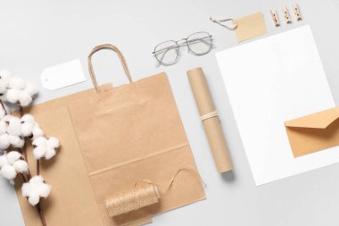 Pamuk çiçekli kompozisyon, sicim ve gri arka planda teslimat kağıdı.