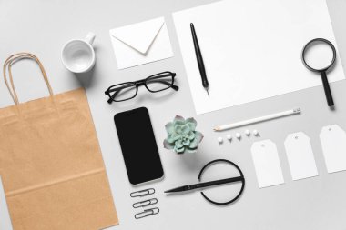 Gri arkaplanda cep telefonu, makas ve teslimat kağıdı içeren kompozisyon