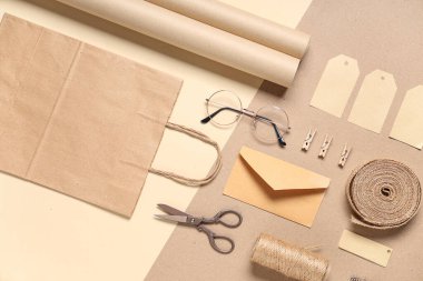 Bej arka planda gözlük, sicim, makas ve teslimat kağıdı içeren kompozisyon