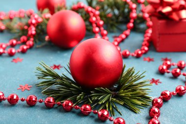 Noel topları, köknar dalları ve mavi arka planda kırmızı boncuklar ile güzel kompozisyon, yakın plan
