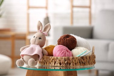 Evdeki sepet iplik, kanca ve kahve masasında örülmüş tavşan oyuncağı.