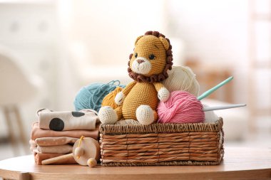Evde sepet iplik, kanca ve örülmüş aslan oyuncağı var.