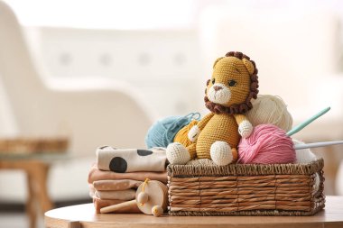 Evde sepet iplik, kanca ve örülmüş aslan oyuncağı var.
