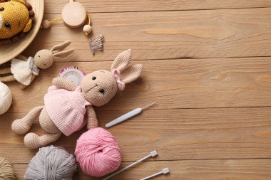 Ahşap arka planda iplik ve örgü aletleriyle örülmüş oyuncaklar