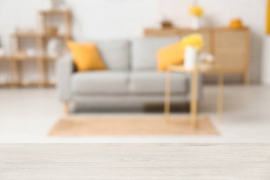 Oturma odası, kanepe, şifonyer ve narsist çiçekli bulanık bir masa.