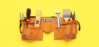 Sarı arkaplanda inşaat araçları olan kemer