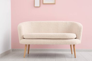 Pembe duvarın yanındaki rahat beyaz kanepe