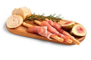 Lezzetli İtalyan Grissini tahtasının beyaz arka planında jambon, ekmek ve incir var.