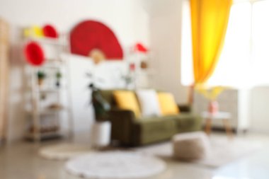 Japon Yeni Yıl kutlamaları için kanepe, raf üniteleri ve dekorla aydınlık oturma odasının bulanık görüntüsü