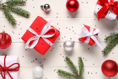 Noel hediyesi kutuları köknar ağacı dalları ve beyaz ahşap arka planda toplar.