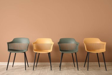 Kahverengi duvarın yanındaki modern koltuklar