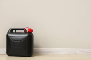 Beyaz duvarın yanındaki siyah plastik kutu.