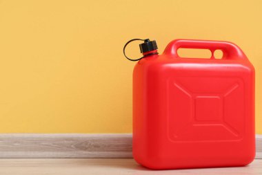 Sarı duvarın yanındaki kırmızı plastik kutu.