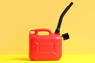 Sarı arka planda lastik başlıklı kırmızı plastik kutu.