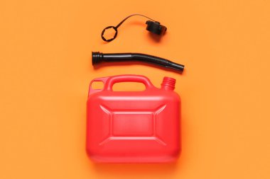 Turuncu arka planda lastik başlıklı kırmızı plastik kutu.