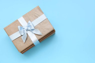 Mavi arka planda hediye kurdelesiyle bağlanmış kitap yığını