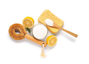 Limonlu bir kase kabartma tozu, beyaz arka planda temizlik süngeri ve fırça