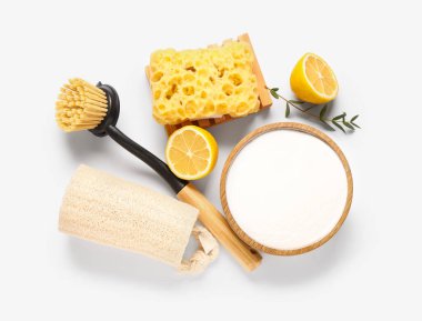 Limonlu kabartma tozu ve beyaz arka planda temizlik malzemeleri.