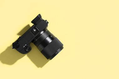 Sarı arka planda modern profesyonel fotoğraf makinesi